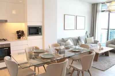 a living room with a glass table and chairs at Palace Residences luxurious 2 bedroom with breathtaking views in Dubai