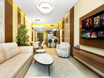 a living room with a couch and a tv at Stylish 1BHK Balcony with Canal View Near Shoba Metro Station in Dubai