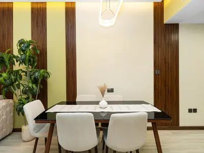 a dining room with a black table and white chairs at Stylish 1BHK Balcony with Canal View Near Shoba Metro Station in Dubai