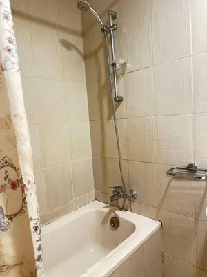 a bathroom with a tub and a shower with a shower curtain at Tranquil & Elegant Studio in Dubai Sports City in Dubai