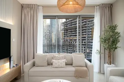 a living room with a couch and a large window at Stylish 1BR Apartment near Burj Khalifa and Dubai Fountain, Downtown in Dubai