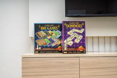 three games are sitting on top of a shelf at Stylish 1BR Apartment near Burj Khalifa and Dubai Fountain, Downtown in Dubai