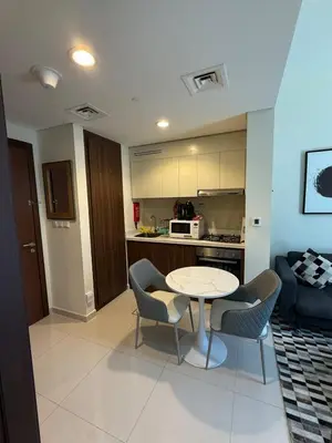 a kitchen and a living room with a table and chairs at Stylish 1-Bedroom Apartment near burj khalifa in Dubai