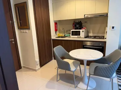 a small kitchen with a white table and chairs at Stylish 1-Bedroom Apartment near burj khalifa in Dubai