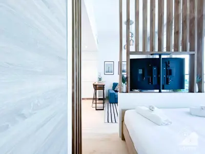 a bedroom with a bed and a tv on the wall at Balcony Bliss Cozy Studio with Marina Views in Dubai