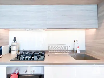 a kitchen with a sink and a stove top oven at Balcony Bliss Cozy Studio with Marina Views in Dubai
