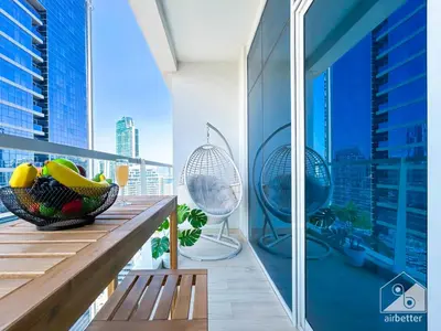 a balcony with a view of a city with a bowl of fruit at Balcony Bliss Cozy Studio with Marina Views in Dubai