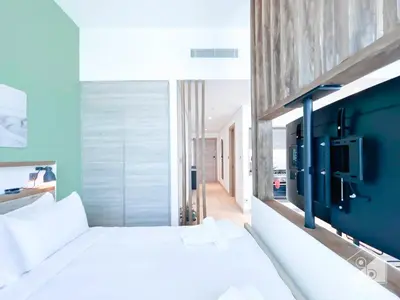 a bedroom with a white bed and a blue wall at Chic New Studio at Studio One Marina in Dubai