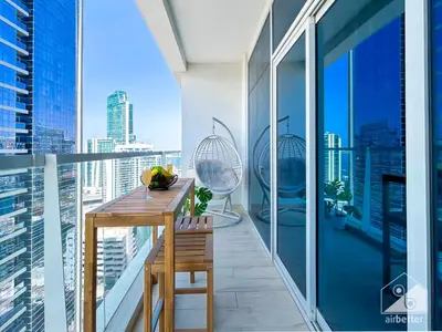 a balcony with a wooden table and a view of the city at Chic New Studio at Studio One Marina in Dubai