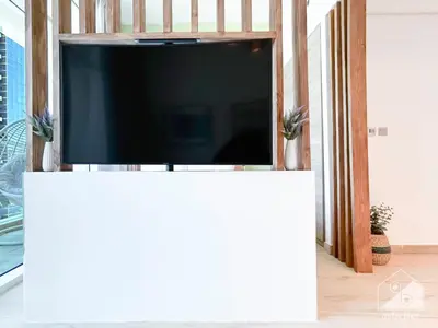 a flat screen tv on a white stand in a living room at Chic New Studio at Studio One Marina in Dubai