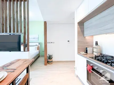 a kitchen with white walls and a wooden counter top at Chic New Studio at Studio One Marina in Dubai