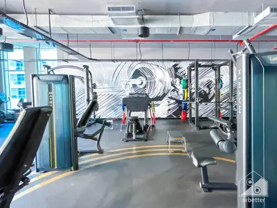 a gym with cardio equipment and a mural on the wall at Chic New Studio at Studio One Marina in Dubai