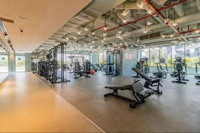a gym with several treadmills and machines in it at Vogue Downtown Mag318 near Burj Khalifa and Dubai Mall, Studio Apartment with Balcony, Canal and City View, Access to all Amenities in Sabkhah