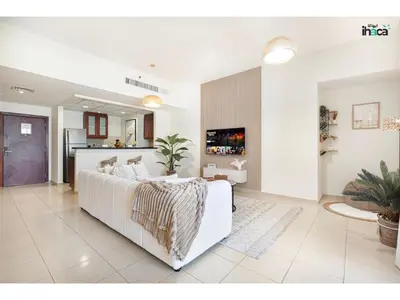 a living room with a white couch and a kitchen at Boho Studio Beachfront Ain Sea View JBR Walk 1min in Dubai