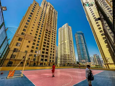 two people playing basketball on a basketball court in a city at Boho Studio Beachfront Ain Sea View JBR Walk 1min in Dubai