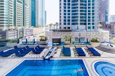 a swimming pool with blue lounge chairs next to a building at Zen Den - Vintage Charm with full Sea View in Dubai
