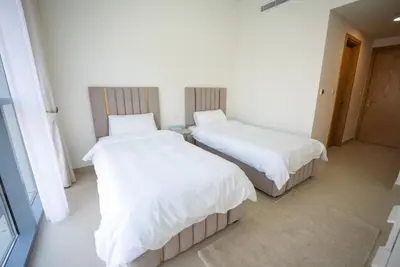 two beds in a room with white sheets at Luxury 2bdr apartment with Burj views & resort amenities in Dubai