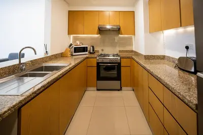a small kitchen with a stove and a sink at Luxury 2bdr apartment with Burj views & resort amenities in Dubai