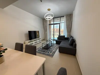 a living room with a couch and a tv at Luxury 2bdr apartment with Burj views & resort amenities in Dubai