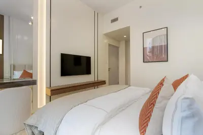 a bedroom with a white bed and a television at 313 Downtown Luxury Living at it's Finest in Dubai