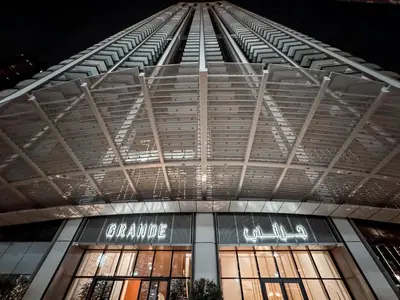 a view of a building at night with lights on at GRANDE SIGNATURE with a direct Burj Khalifa view and Private Fountain Show at high floor with DXB AIRPORT VIP Shuttle option for 6 guests in Dubai