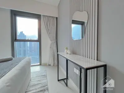a bedroom with a bed and a mirror and a window at Burj Crown Luxury 2BR I Balcony & Panoramic Views in Dubai