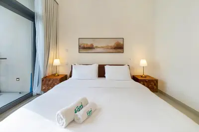 a bedroom with a large white bed and two lamps at FAM Living - 3BR Creekside Escape in Creek Rise Tower 2 in Dubai