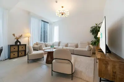 a living room with a couch and a table and chairs at FAM Living - 3BR Creekside Escape in Creek Rise Tower 2 in Dubai