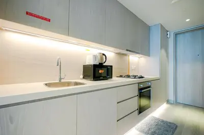 a kitchen with a sink and a microwave at Stylish Studio at Concord Concept, JVC in Dubai