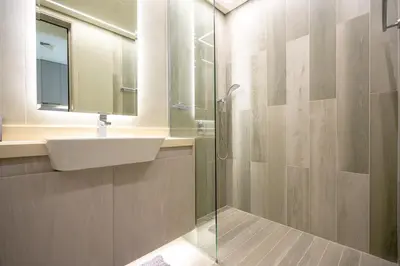 a bathroom with a sink and a glass shower at Stylish Studio at Concord Concept, JVC in Dubai