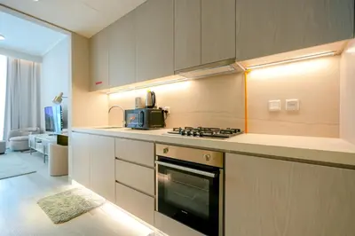 a kitchen with a stove and a microwave at Stylish Studio at Concord Concept, JVC in Dubai