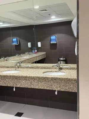 a public bathroom with three sinks and mirrors at Elegant Master bedroom with view in Dubai