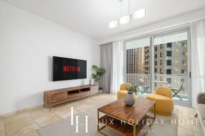 a living room with a tv and a table at LUX The Luxury Sunny JBR Beach Views 2 in Dubai