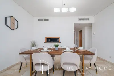 a dining room with a wooden table and chairs at LUX The Luxury Sunny JBR Beach Views 2 in Dubai