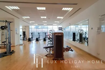 a gym with treadmills and machines in a room at LUX The Luxury Sunny JBR Beach Views 2 in Dubai