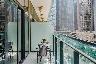 a balcony with a table and chairs and a view of a city at RH- Elegant & Cozy 1BR , Prime Location , Walk to Metro Station in Dubai