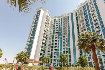 a tall building with palm trees in front of it at Cosy studio Free Parking Free unlimited drinkable water Near Downtown in Dubai