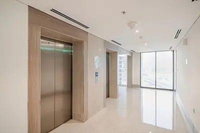 a hallway of an office building with a elevator at Cosy studio Free Parking Free unlimited drinkable water Near Downtown in Dubai