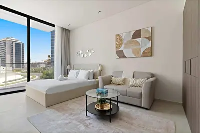 a bedroom with a bed and a couch and a table at Bright & Cozy Studio in a new residence in Arjan in Dubai