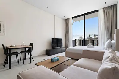 a living room with a couch and a bed and a table at Bright studio in Arjan with pool gym and parking in Dubai
