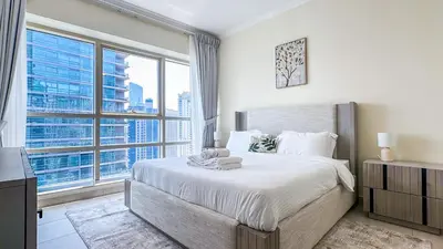 a bedroom with a large bed and a large window at Relaxing Marina View Stay, Walk to Beach & Mall - 27AB02 in Dubai