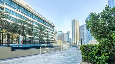 a view of a building with palm trees in a city at Relaxing Marina View Stay, Walk to Beach & Mall - 27AB02 in Dubai