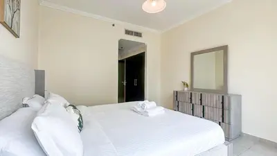 a bedroom with a white bed and a mirror at Relaxing Marina View Stay, Walk to Beach & Mall - 27AB02 in Dubai