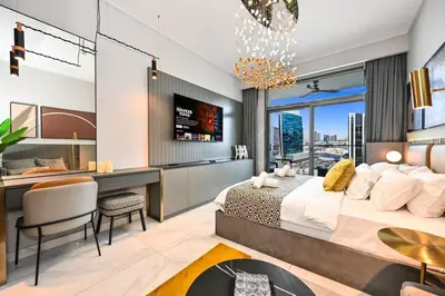 a bedroom with a large bed and a desk and a desk at Luxury Studio mints Walk to Dubai Mall & Burj Khalifa in Dubai
