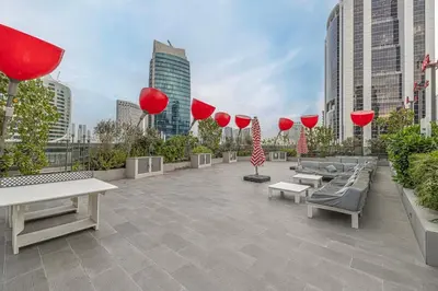 a patio with benches and red umbrellas in a city at Luxury Studio mints Walk to Dubai Mall & Burj Khalifa in Dubai