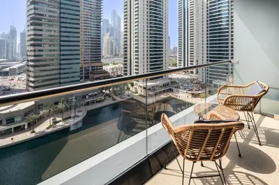 two chairs on a balcony with a view of the city at Luxury JLT Studio Lake View Metro Pool Access in Dubai