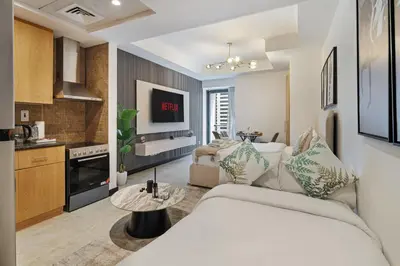 a living room with a bed and a kitchen at Luxury JLT Studio Lake View Metro Pool Access in Dubai