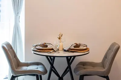 a table with two chairs and a plate of food on it at Luxury JLT Studio Lake View Metro Pool Access in Dubai