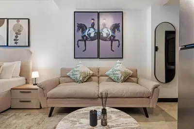 a living room with a couch and paintings on the wall at Luxury JLT Studio Lake View Metro Pool Access in Dubai