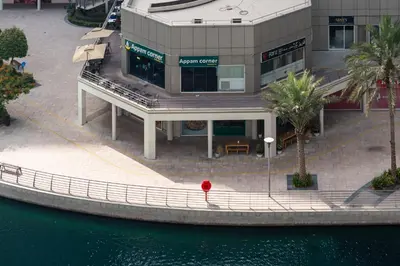 a building with a red object in front of the water at Luxury JLT Studio Lake View Metro Pool Access in Dubai